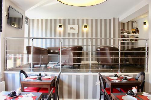 a restaurant with two tables and chairs in a room at Logis Hotel - Le Charleston in Le Mans