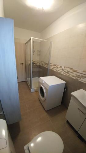 a bathroom with a washing machine and a toilet at Apartment Maskaric in Cavtat