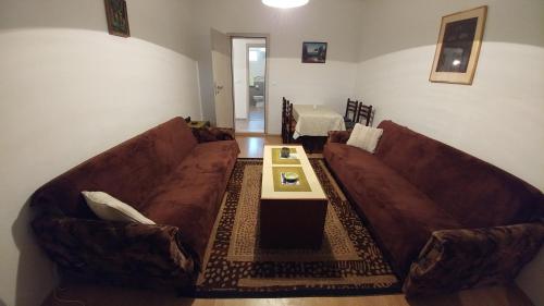 a living room with two brown couches and a table at Apartment Maskaric in Cavtat