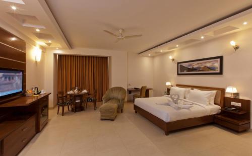 a hotel room with a bed and a television at Lemon Tree Hotel Baddi in Baddi
