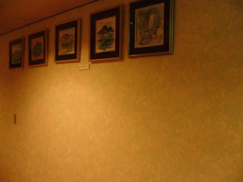 a group of pictures on a wall in a room at Hotel Senke in Myoko