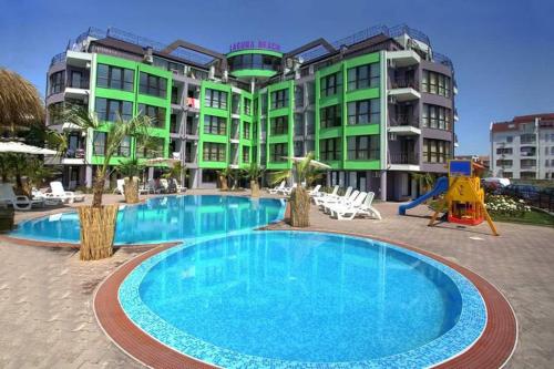 a large swimming pool in front of a building at Laguna Beach Apartments with Sea View in Ravda