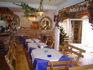 un restaurante con mesas y sillas y una habitación con en Pansion Sport en Štinjan