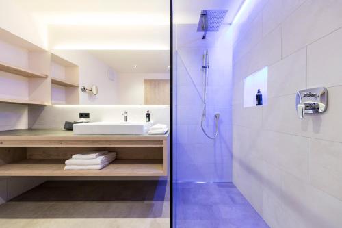 y baño con ducha, lavabo y aseo. en Hotel Torgglhof en Caldaro