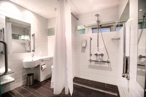 鄧迪的住宿－Sleeperz Hotel Dundee，带淋浴和盥洗盆的白色浴室
