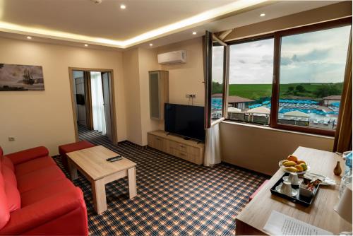 a living room with a red couch and a large window at SPA Kompleks Raiski Kat in Dimitrovgrad