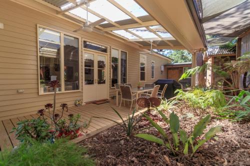 an outdoor patio with a pergola and a table at The Oaks Lilydale Accommodation in Lilydale
