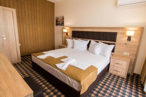 a hotel room with a large bed with towels on it at SPA Kompleks Raiski Kat in Dimitrovgrad