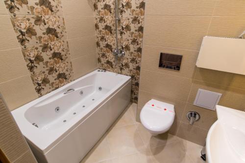 a bathroom with a tub and a toilet and a sink at SPA Kompleks Raiski Kat in Dimitrovgrad