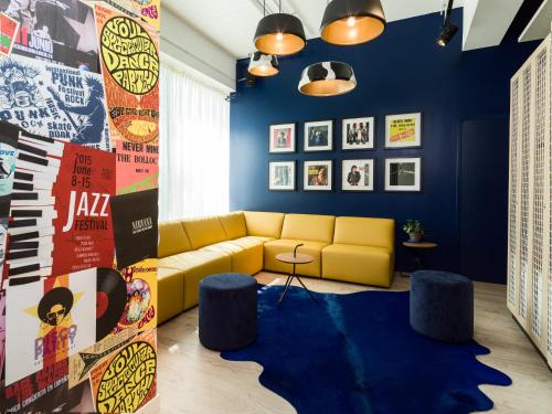 a living room with a yellow couch and blue walls at Holiday Inn - the niu, Dairy Haarlem in Haarlem