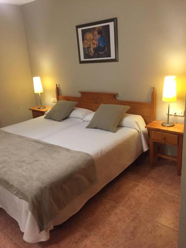 a bedroom with a large white bed with two lamps at Hotel Florido in Sort