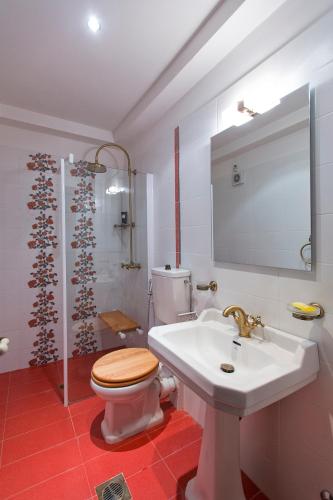 a bathroom with a toilet and a sink and a shower at Villa Larisa in Gastouri