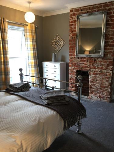 a bedroom with a bed and a brick fireplace at The City Pad in Norwich