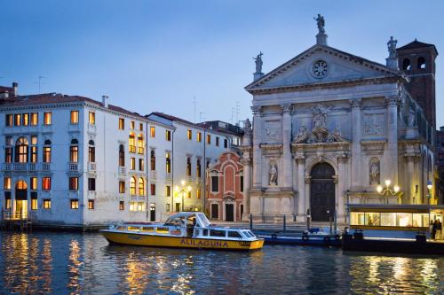 a yellow boat in the water in front of a building at Hotel Palazzo Giovanelli e Gran Canal in Venice