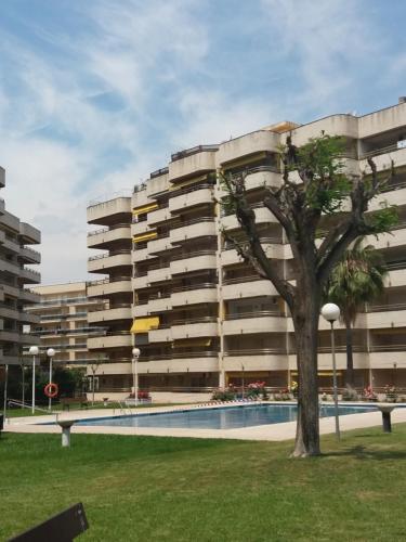 un bâtiment avec un arbre en face dans l'établissement Bonito Apartamento con varias piscinas, à Salou