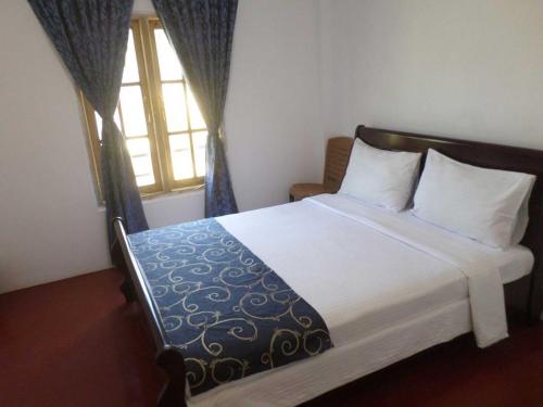 a bedroom with a large bed with a window at The Train View in Nuwara Eliya