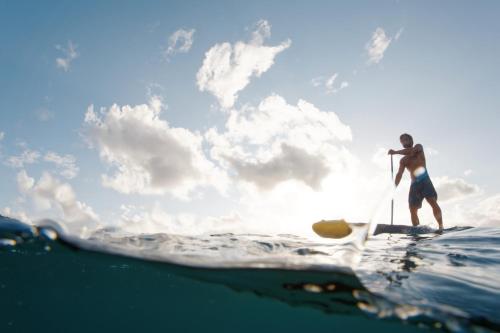 a man on a paddle board in the ocean at Sentidos Beach Retreat in Miramar