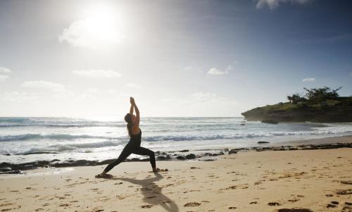 a woman doing a yoga pose on the beach at Sentidos Beach Retreat in Miramar