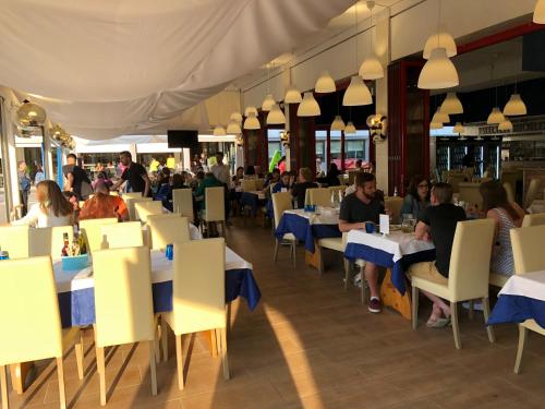 a restaurant with tables and people sitting at tables at Hotel Adriatico in Bibione