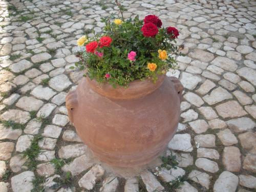 a large vase filled with flowers on a brick ground at Casa vacanze La Meridiana in Donnalucata