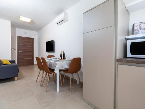 a kitchen and dining room with a table and chairs at Apartments Gioia in Poreč
