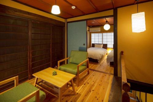 a room with a bedroom and a bed and a table at Kumashu an Machiya House in Kyoto