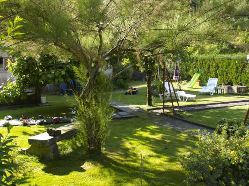a park with a tree and a bench in the grass at Aux Studios du Parc in Plombières-les-Bains