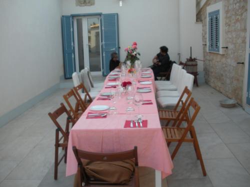 a long table with a pink table cloth on it at Casa vacanze La Meridiana in Donnalucata