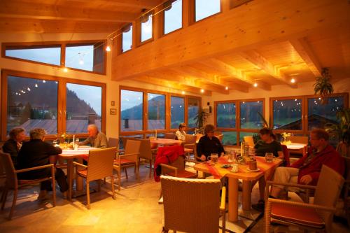 un groupe de personnes assises à table dans un restaurant dans l'établissement Pension Gatterer, à Maria Luggau