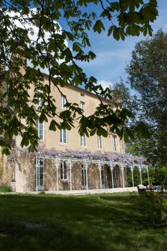 an exterior view of a building with purple flowers at B&B Château de Fajac la Selve in Pech-Luna