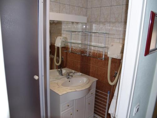 a bathroom with a sink and a mirror at Aux Studios du Parc in Plombières-les-Bains