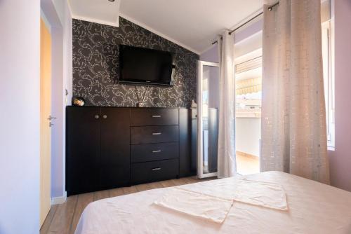 a bedroom with a bed and a tv on a wall at Boki Apartment Split in Split