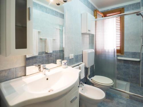 bagno con lavandino bianco e servizi igienici di siciliacasevacanze - Casa Girasole a Marina di Ragusa