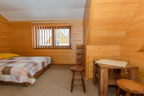 - une chambre avec un lit, une table et une fenêtre dans l'établissement Apartamenty U Zajaców, à Zakopane