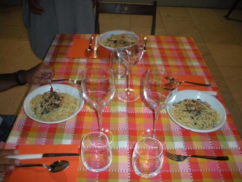 a table with wine glasses and plates of pasta at Casa vacanze La Meridiana in Donnalucata