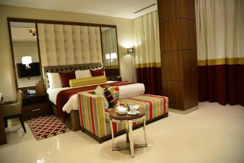 a hotel room with a bed and a table in a room at The Envoy Hotel Abuja in Abuja