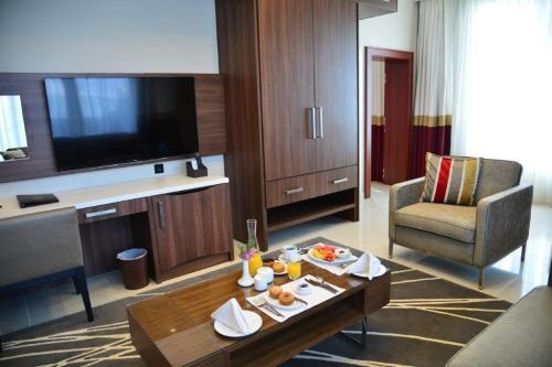 a living room with a table in a hotel room at The Envoy Hotel Abuja in Abuja