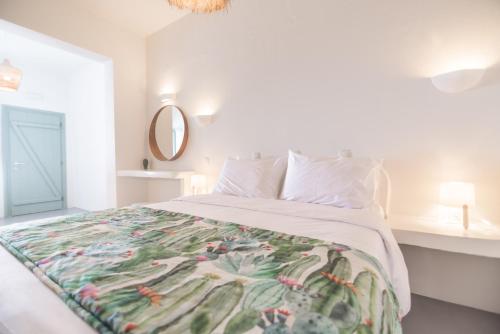a bedroom with a white bedspread and pillows at Agave Santorini Design Boutique Hotel in Imerovigli