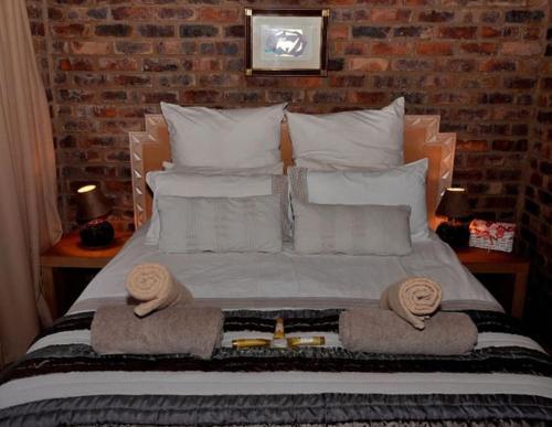 a bedroom with a bed with towels on it at Tranquillity Day Spa & Lodge in Baviaanspoort