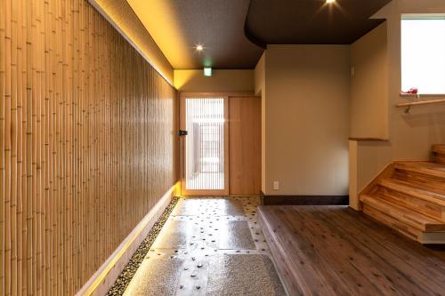 a room with a hallway with wooden floors and a window at Hisashi in Kyoto