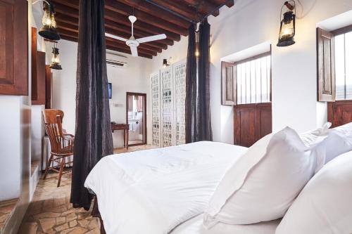 a bedroom with a white bed and a table at XVA Art Hotel in Dubai
