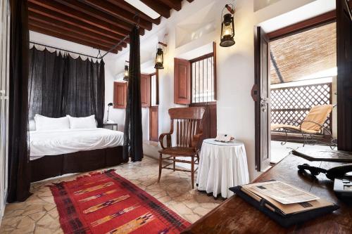 a bedroom with a bed and a table and a chair at XVA Art Hotel in Dubai