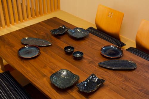 a wooden table with plates and utensils on it at Hisashi in Kyoto