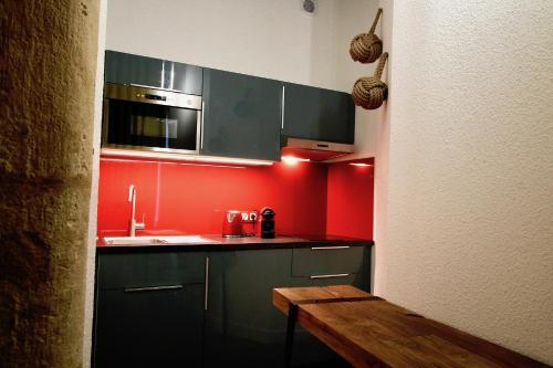 - une cuisine avec des murs rouges et un comptoir dans l'établissement 3e secret en plein coeur du Vieux Lyon, à Lyon