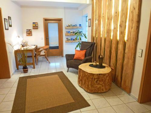 a living room with a tree stump table and a chair at Ferienwohnungen Finke in Frankenau
