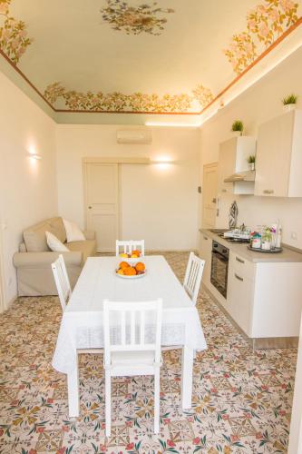a dining room with a white table and chairs at Pandora in Porticello