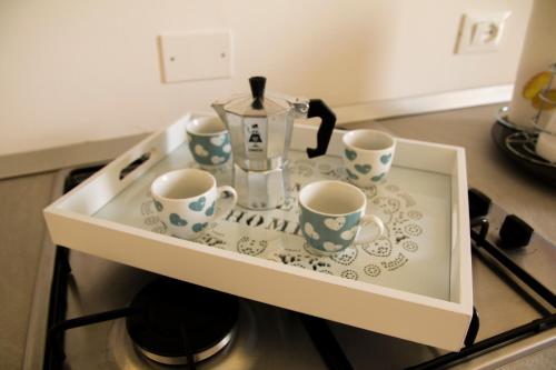 a cabinet with cups and a tea pot on a stove at Pandora in Porticello
