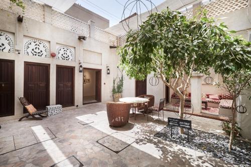 a courtyard with a table and chairs and a tree at XVA Art Hotel in Dubai