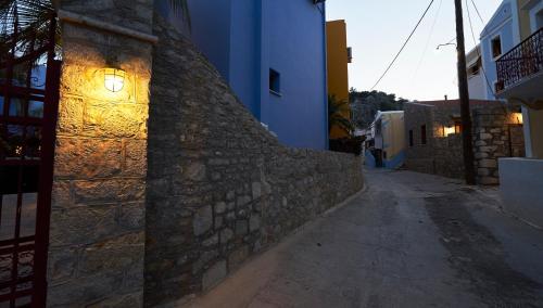 a stone wall with a light on the side of a building at Kaminos Boutique Hotel in Symi