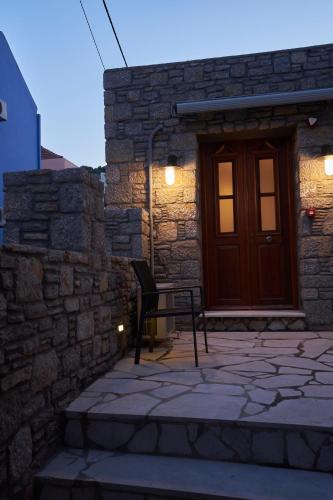 a building with a wooden door and a chair in front at Kaminos Boutique Hotel in Symi